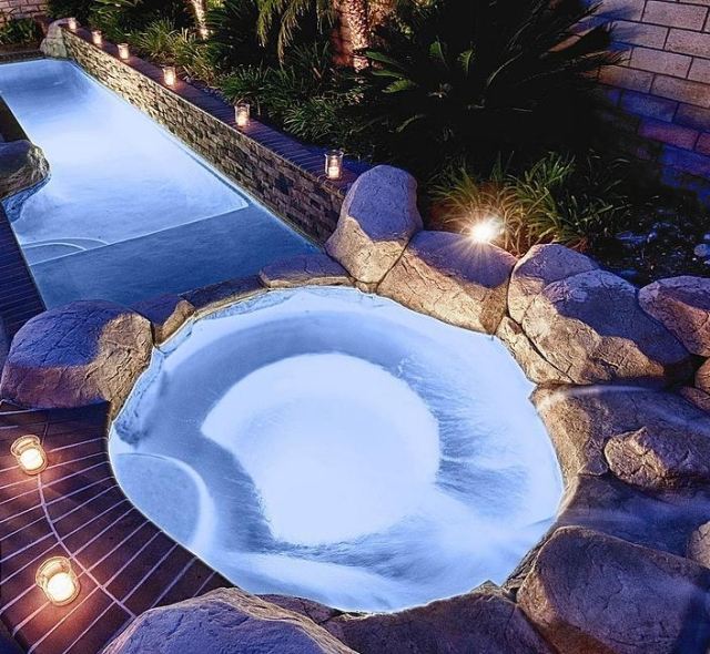 حوض سباحة دائري محاط بأفكار تصميم حديقة مصقولة بالحجارة