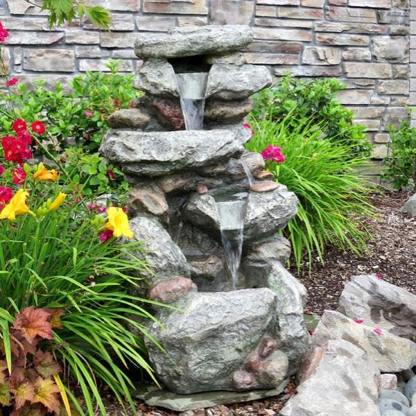 بناء نافورة مياه في الفناء الخلفي مصنوعة من الحجر الطبيعي وتكتظ بالنباتات