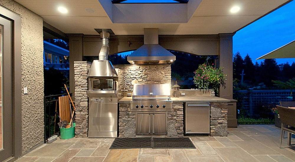 مطبخ خارجي رائع من الفولاذ المقاوم للصدأ مع شواية وتكسية جدارية مصنوعة من الحجر الطبيعي