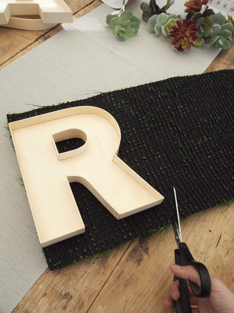 قم بقياس الحرف واستخدم المقص لقطع لفة من العشب الصناعي