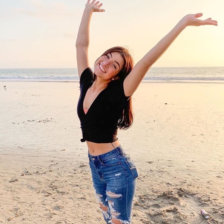 Charli D'Amelio مع بنطال جينز قصير وخصر مرتفع على الشاطئ