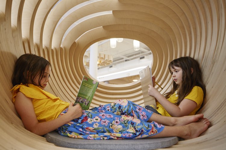 فتاتان تقرأان في شرنقة الخشب