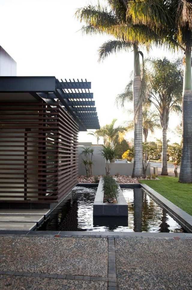 منزل مع المياه المكسوة بالخشب حديقة فناء تصميم حديقة النخيل