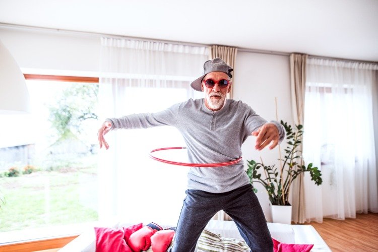 سعيد رجل كبير السن يرقص مع النظارات الوردية في الغرفة