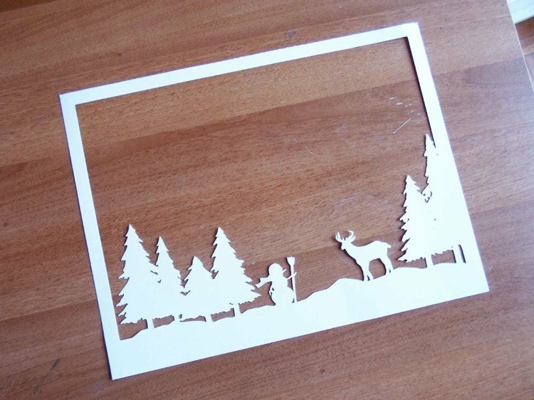 فكرة لصورة عيد الميلاد للنافذة - رجل ثلج وغزلان في غابة على أشجار الصنوبر