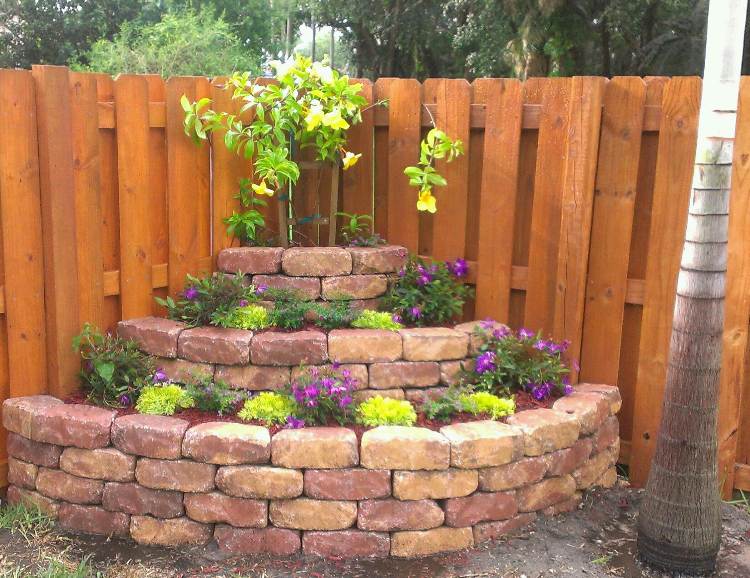 تصميم ركن الحديقة flowerbed على الطوب السياج