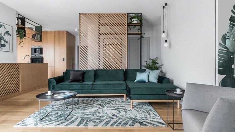 أريكة خضراء كبيرة مع سجادة رمادية مع نمط أوراق الشجر