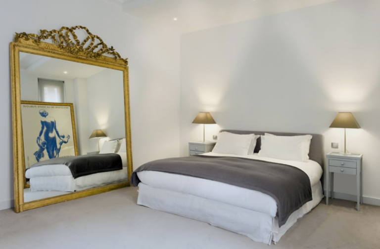 غرفة نوم كبيرة معدة بدون أثاث مع مرآة ضخمة وصورة على الحائط