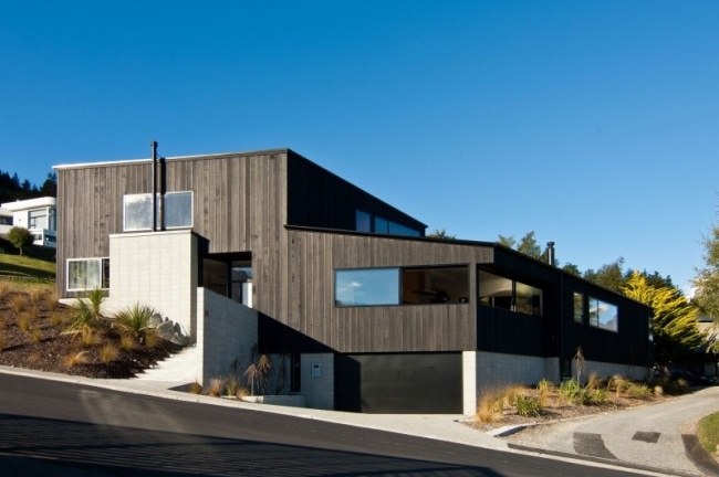 تصميم منزل معماري خارجي ، كسوة جدران من خشب الأرز باللون الأسود مبنية على جانب التل