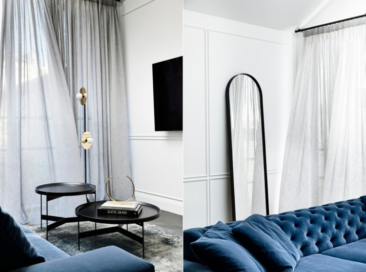 غرفة معيشة مشرقة مع أريكة زرقاء وأغطية حائط بيضاء