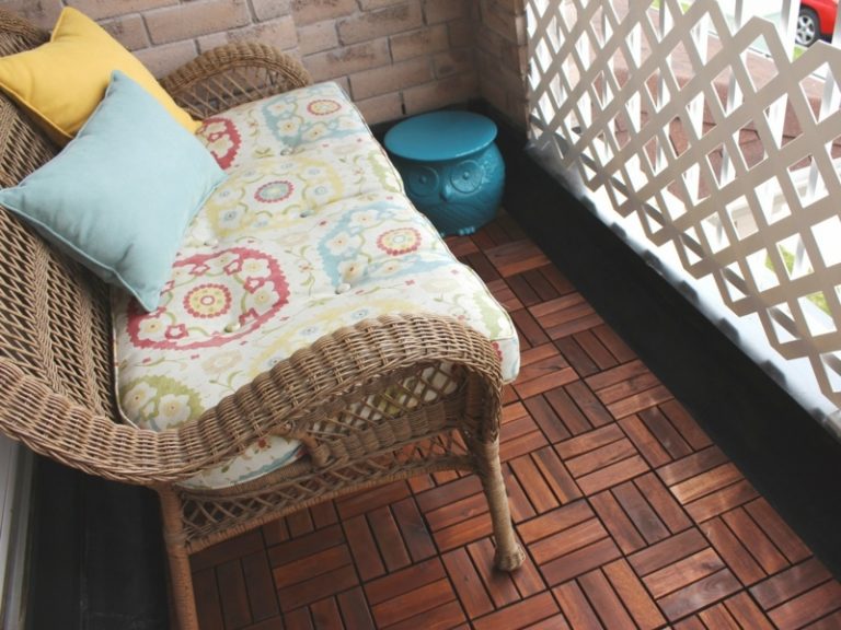 بلاط خشبي على شرفة أريكة صغيرة سلة تنجيد ملونة