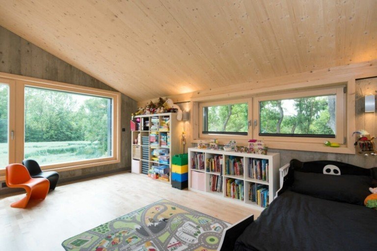 غرفة الأطفال الداخلية من الخشب والخرسانة وأرفف السرير ذات السقف المائل