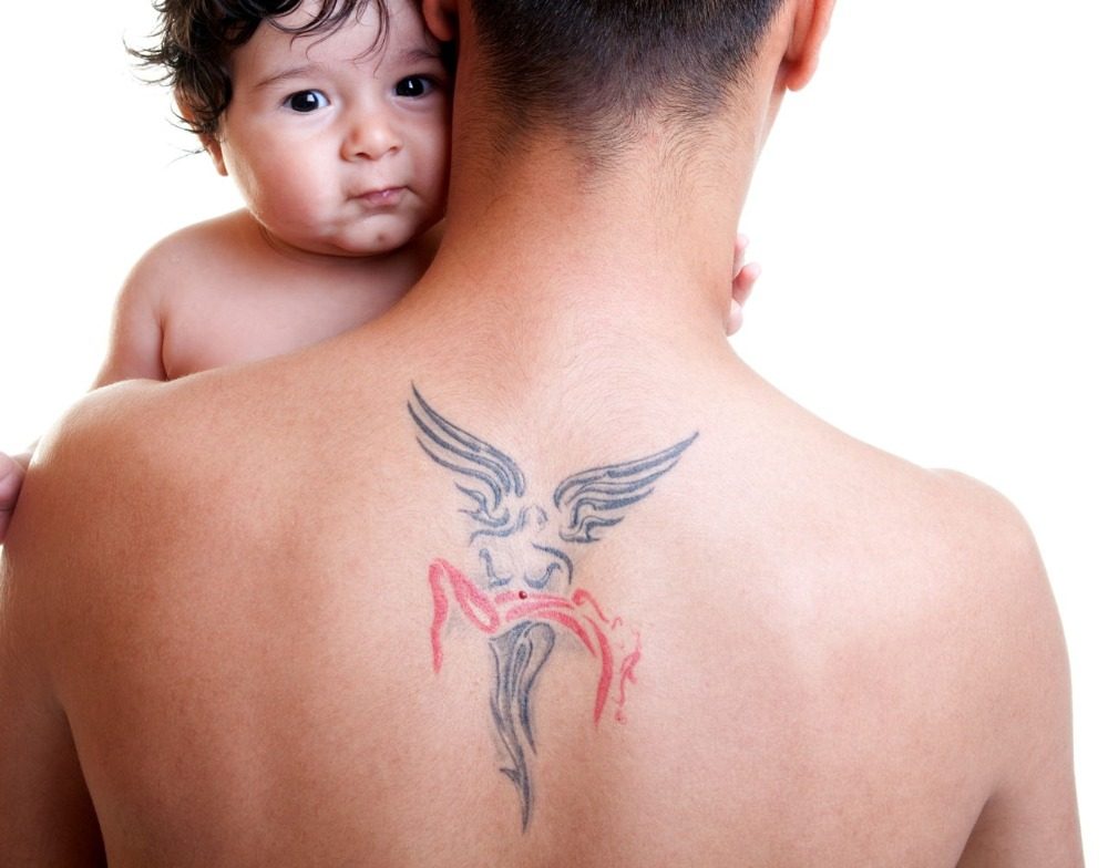 الأب مع الملاك الخلفي الوشم يحمل طفله موضوعيا