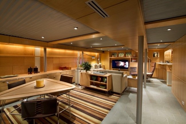 تجديد الطابق السفلي الألواح الخرسانية الخشبية تضيء غرفة المعيشة ومنطقة تناول الطعام