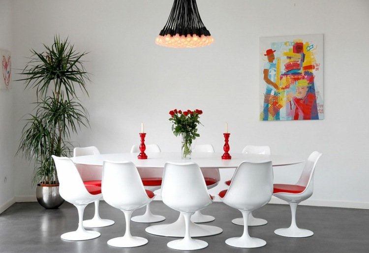 تأثيث غرفة طعام حديثة طاولة طعام بيضاء بيضاوية لهجات حمراء وديكورات الورد