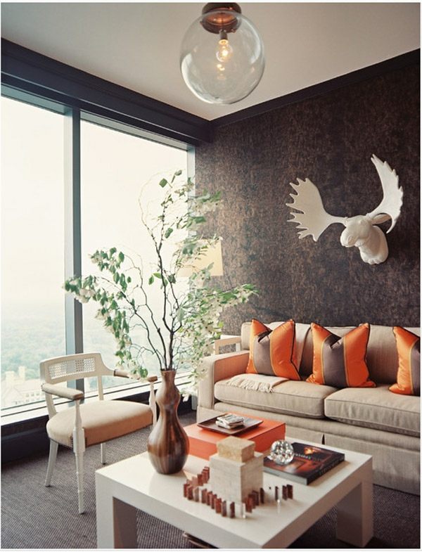 خلفية بنية غرفة المعيشة وسائد زخرفية برتقالية صوفا بيج