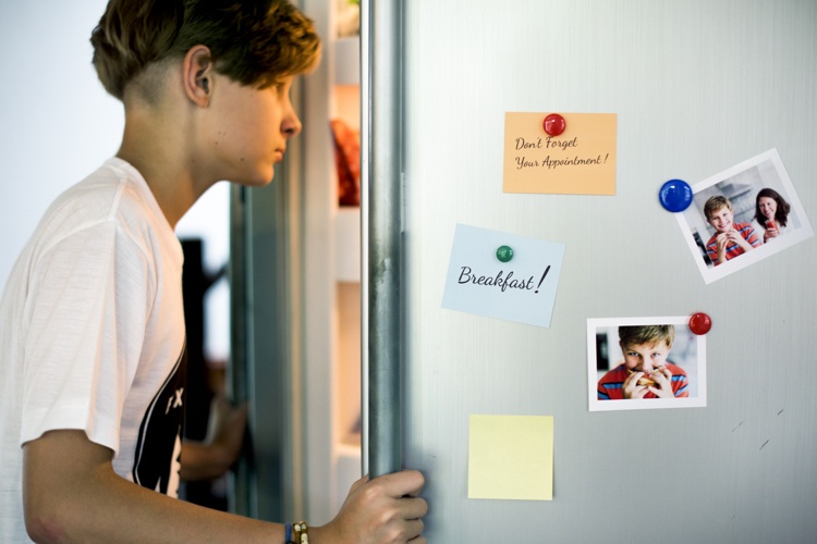 مغناطيس على الثلاجة يحمل ملاحظات وصور عائلية