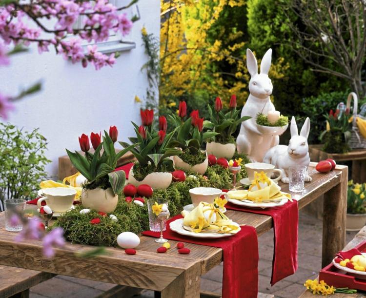 زينة طاولة جميلة باللونين الأحمر والأخضر لعيد الفصح مع زهور الأقحوان والأرانب