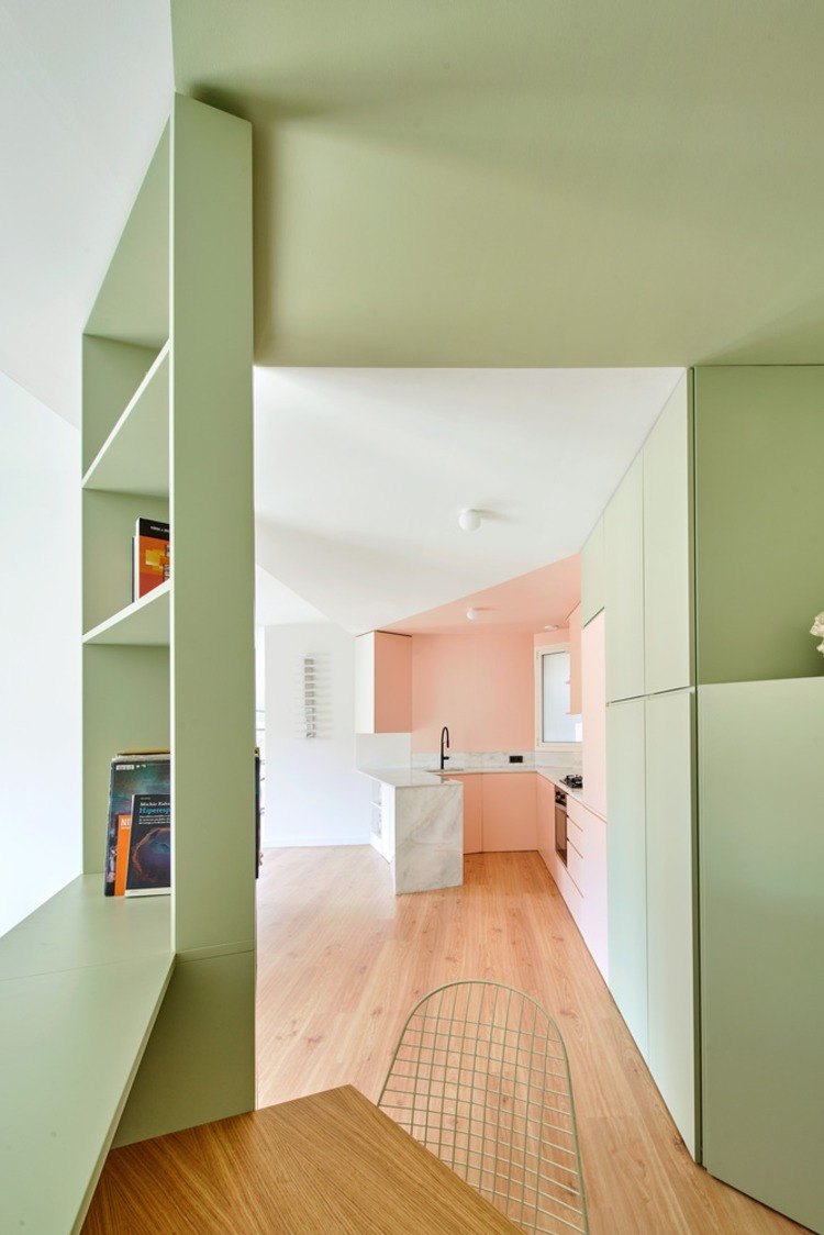 مطبخ مفتوح بجانب مكتب صغير مع رفوف باللون الأخضر النعناعي