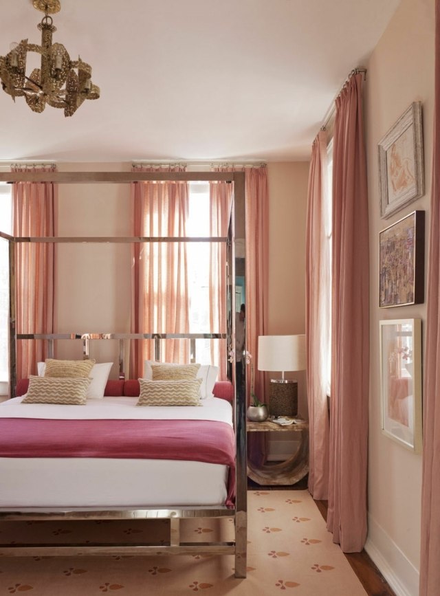 غرفة النوم ستائر باللونين الوردي والأبيض والأحمر وسرير مغطى ذو أربعة أعمدة