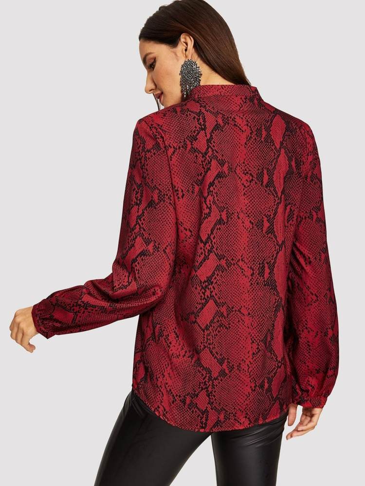 قميص بنمط ثعبان أحمر يجمع بين السراويل الجلدية السوداء