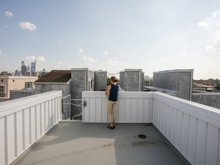 امرأة تنظر إلى المدينة من شرفة السطح
