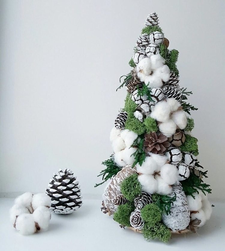 شجرة عيد الميلاد صغيرة مزينة بزهور القطن الطحلبية والأقماع