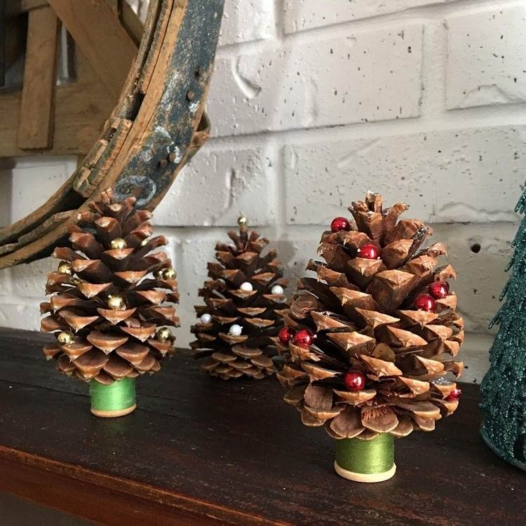 شجرة عيد الميلاد صغيرة مصنوعة من مخاريط مزينة باللآلئ