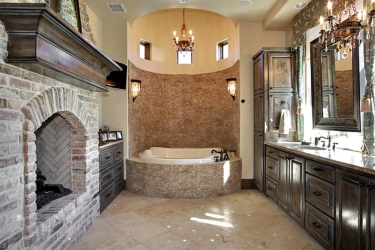 حمام على الطراز الإسباني مع حوض استحمام دائري مع كسوة من الحجر الطبيعي ومدفأة