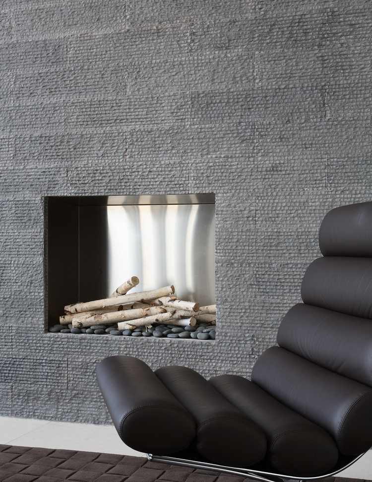 ألواح حجرية رمادية لتكسية الجدران مع مدفأة متكاملة وكراسي جلدية حديثة التصميم