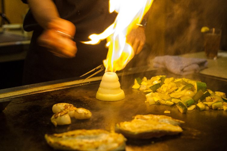تيبانياكي لوحة صينية الطبخ الياباني أطباق غريبة قدمت بشكل جميل البصل مكدسة بركان