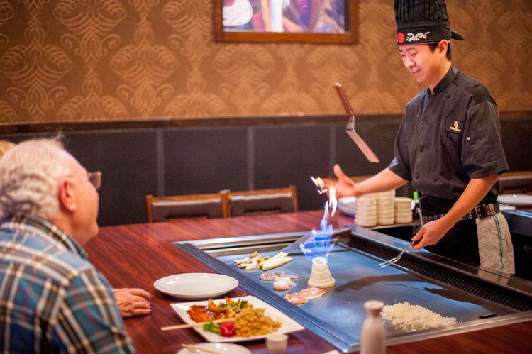 شواية لوحة تيبانياكي الطبخ الياباني أطباق غريبة الأسماك قدمت بشكل جميل مهارات الشيف إظهار بركان البصل رمي الضوء