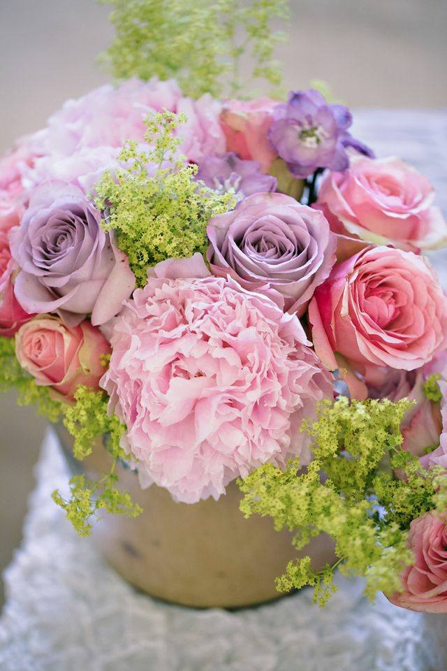 تبدو ترتيبات الزهور من الورود الأرجوانية الوردية على الطاولة طازجة