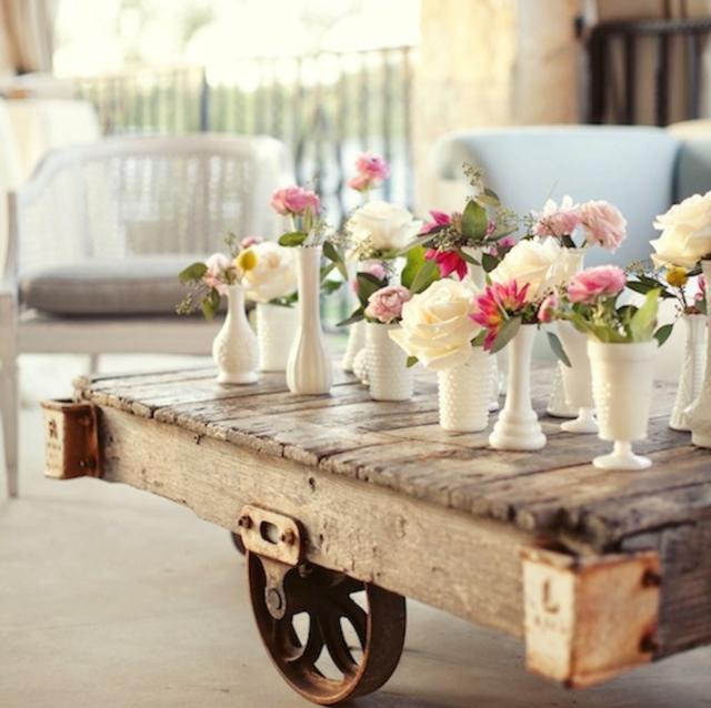 تنسيق زهور الحديقة من الورود على الطاولة مصنوعة من عربة يدوية قديمة
