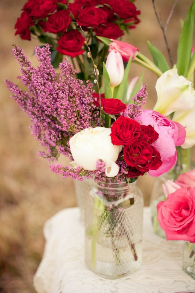 الورود البيضاء القرنفل الأحمر الدلفينيوم الوردي على الطاولة