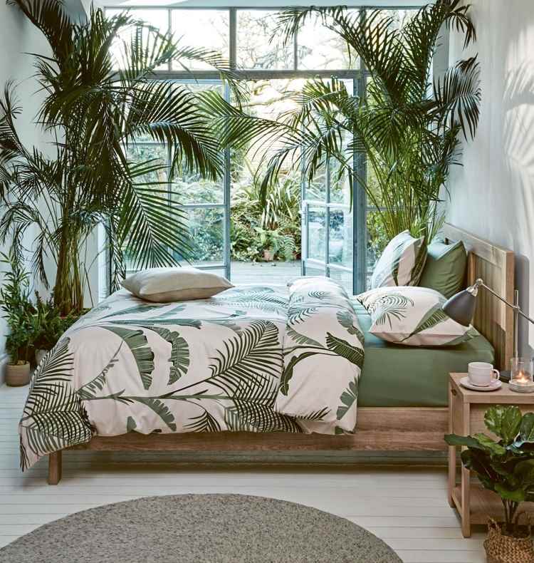 أوراق النخيل الخضراء على أغطية السرير وأثاث غرف النوم الخشبية