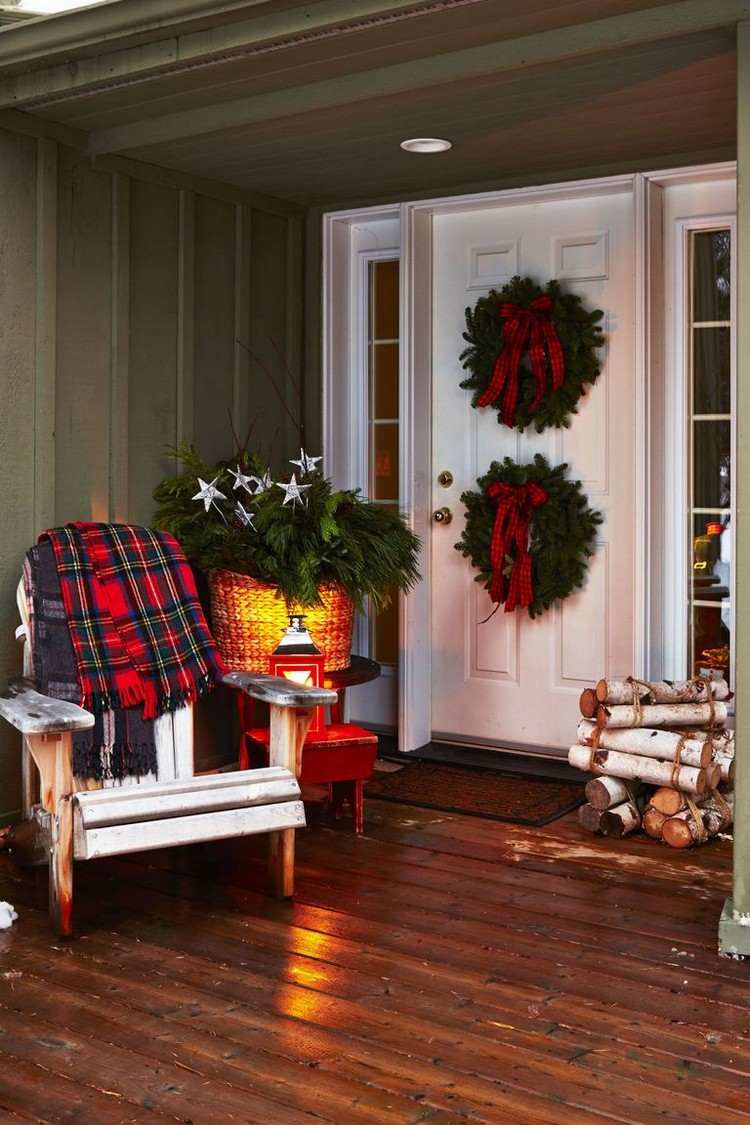 يزين مدخل المنزل في الخارج في عيد الميلاد أكاليل الزهور ذات البابين وترتيب الشتاء