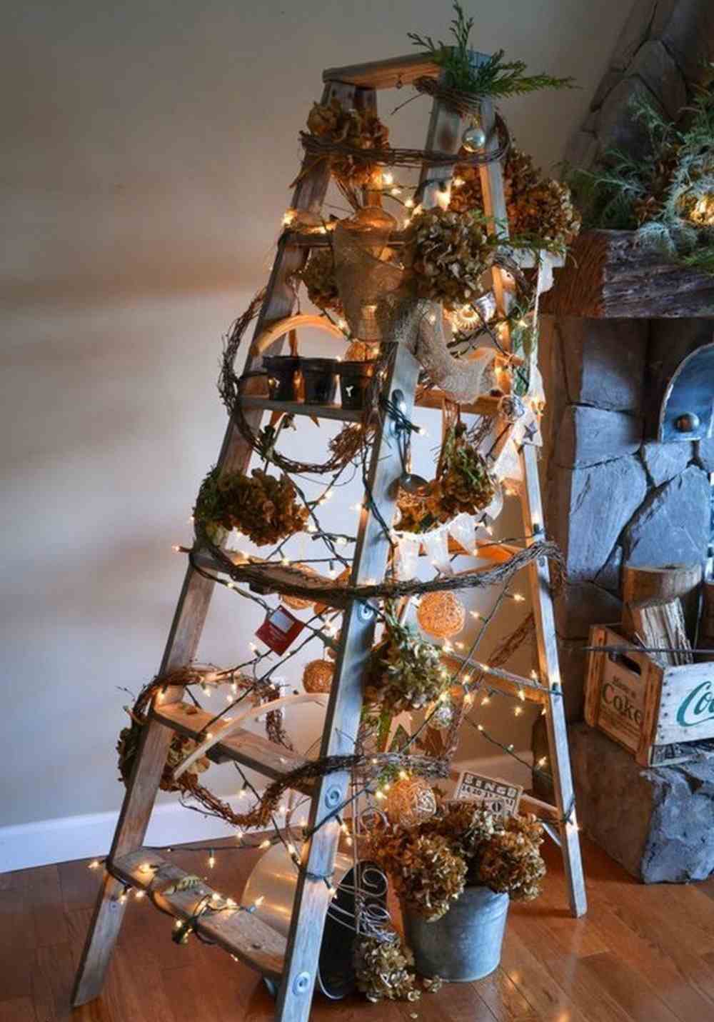 اصنع سلمًا كشجرة عيد الميلاد من الخشب وزينه بأكاليل وأضواء متسلسلة بالإضافة إلى مخاريط الصنوبر