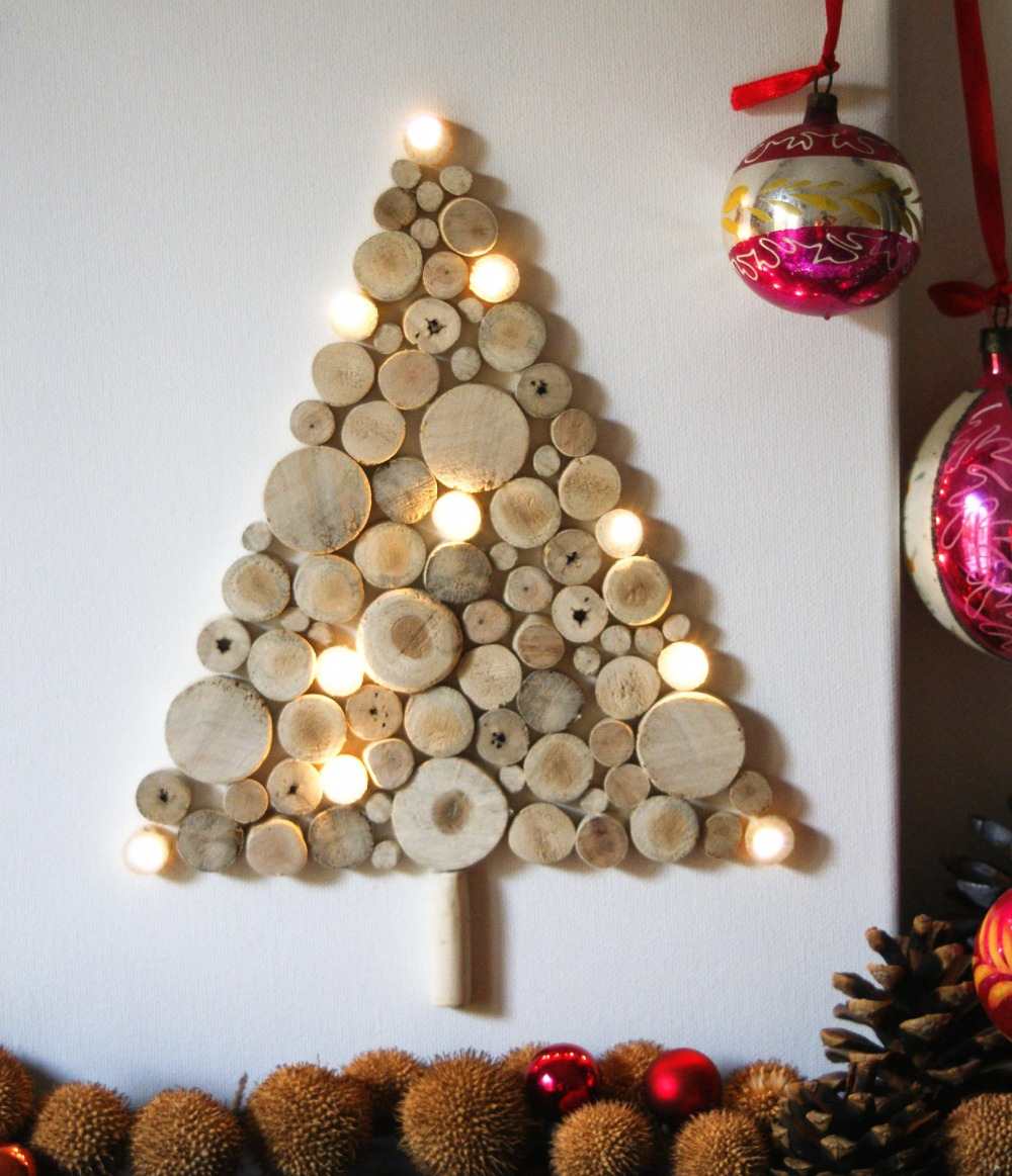 شجرة التنوب مصنوعة من أقراص خشبية مع أضواء LED متصلة بالجدار مع كرات عيد الميلاد