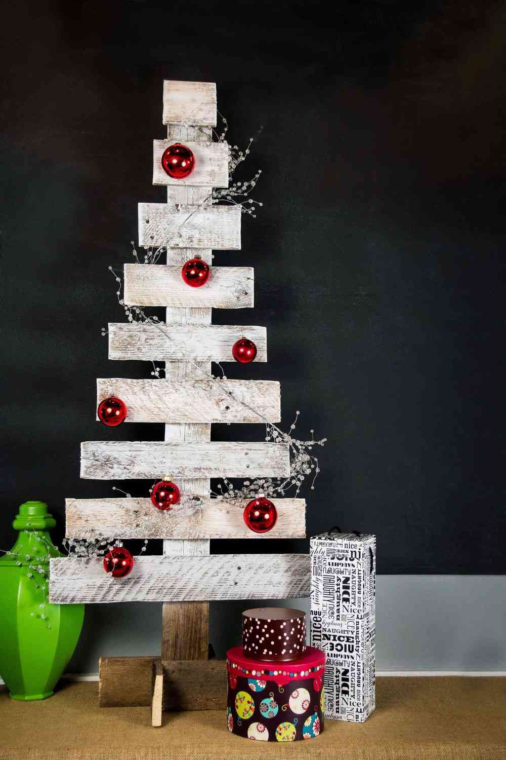 شجرة عيد الميلاد البليت الأبيض مزينة بكرات عيد الميلاد الحمراء وهدايا عيد الميلاد