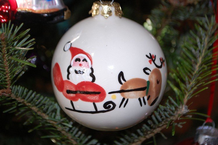 سانتا كلوز في مزلقة ورنة مرسومة ببصمات الأصابع على كرات عيد الميلاد