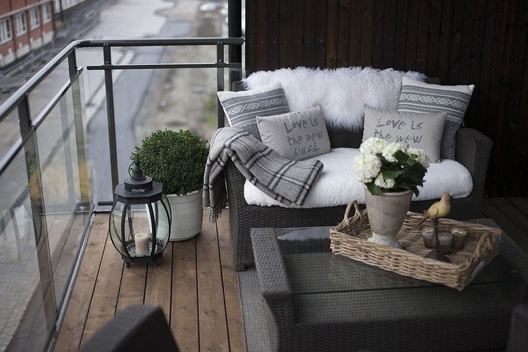 كرة خشب البقس في وعاء بجانب الأريكة على الشرفة في الشتاء