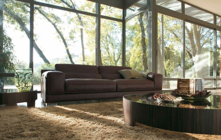 أفكار لغرفة المعيشة مع طاولة قهوة أمامية مستديرة بنوافذ وأريكة عميقة بسجاد بني