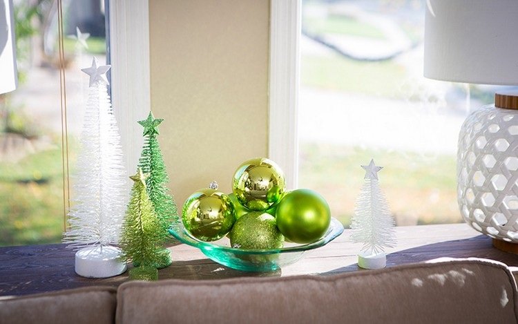 تزيين طاولة القهوة لعيد الميلاد بوعاء من كرات شجرة عيد الميلاد الخضراء وأشجار عيد الميلاد الاصطناعية