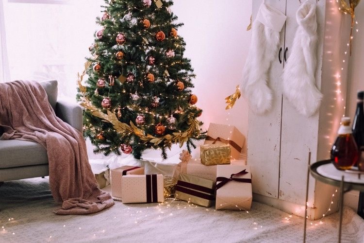 غرفة المعيشة مزينة بشكل احتفالي بأفكار زخرفية مع أضواء خرافية وشجرة عيد الميلاد مع إكليل ذهبي